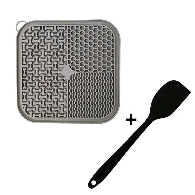 Gray silicone cat lick mat with four lick textures and matching spatula, isolated on white