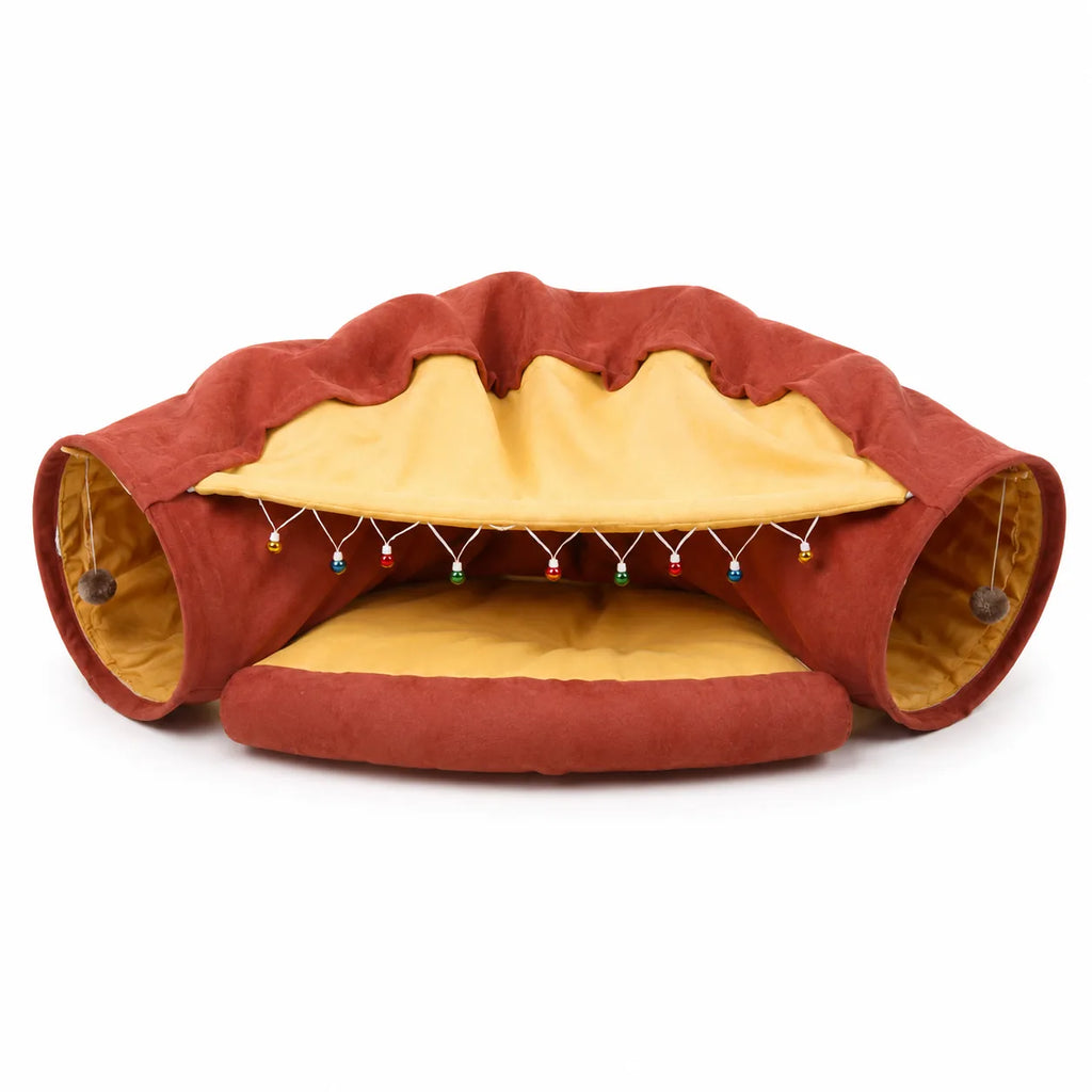 Terracotta and mustard cat tunnel sofa bed with bead garland, studio white background