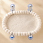 Top-down view of the oval cat window hammock showing the thick plush pad and pom-pom border
