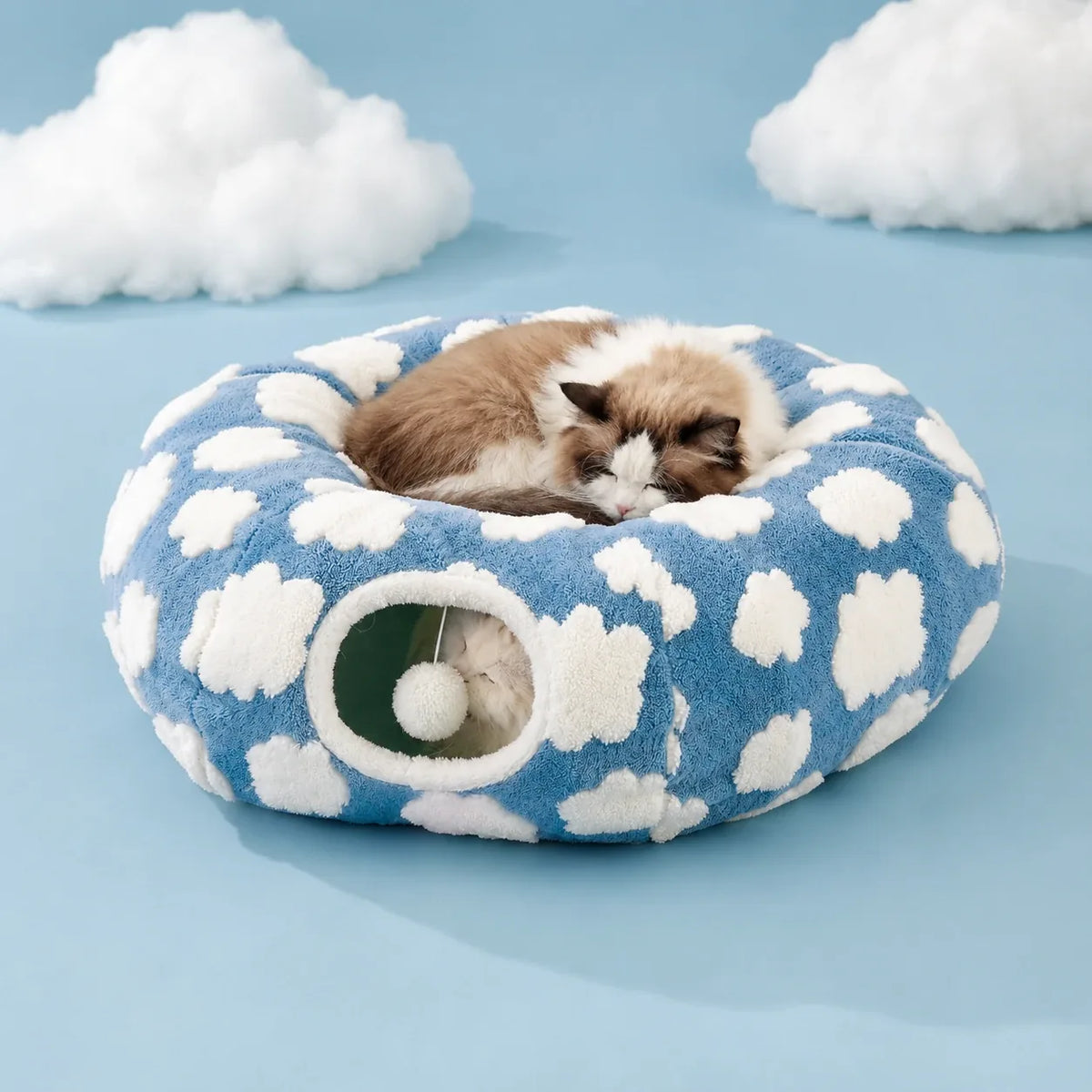 Cat sleeping curled on top of the assembled cloud donut tunnel bed
