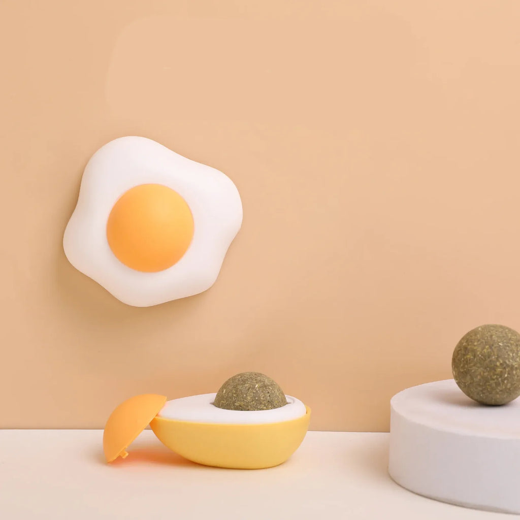 Egg catnip balls mounted on a wall with a catnip ball beside