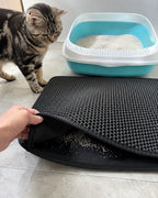 Lifting the top layer to pour trapped litter back into the box