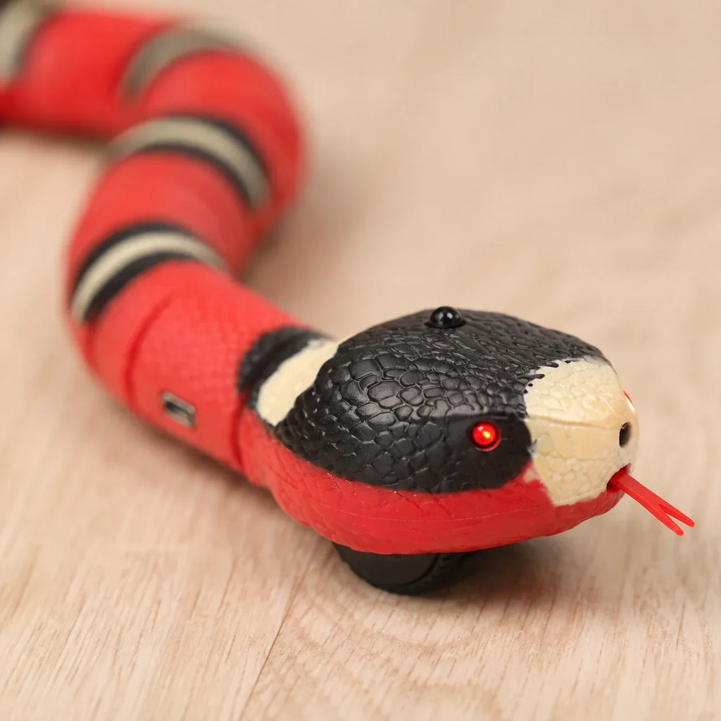 Close-up of the smart snake cat toy head with glowing red LED sensor eye and flicking tongue
